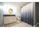 Neutral-toned bathroom with a granite-top vanity, tile floor, and shower curtain at 14 Whit Ct, Angier, NC 27501