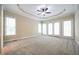 Spacious carpeted bedroom with ceiling fan, tray ceiling and french doors at 14 Whit Ct, Angier, NC 27501
