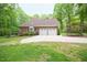 Rear view of a brick home with a two-car garage and a long driveway at 14 Whit Ct, Angier, NC 27501