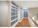 Hallway featuring hardwood floors, built-in bookcases, and staircase with white railing at 14 Whit Ct, Angier, NC 27501