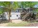 Landscaped backyard with a deck, screened-in porch, and mature trees, providing a private outdoor space at 1514 Goodwin Rd, Durham, NC 27712