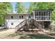 View of the home's rear exterior, showcasing a wooden deck and screened-in porch for outdoor enjoyment at 1514 Goodwin Rd, Durham, NC 27712