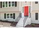 Close-up view of the home's entrance, featuring a red door, white trim, and black iron railings at 1514 Goodwin Rd, Durham, NC 27712
