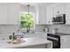 Modern kitchen featuring white cabinets, stainless steel appliances, and quartz countertops at 1514 Goodwin Rd, Durham, NC 27712