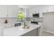 Bright kitchen features white cabinets, modern appliances, light countertops and a large window at 1514 Goodwin Rd, Durham, NC 27712