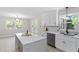 Bright kitchen featuring white cabinets, quartz countertops, and stainless steel appliances at 1514 Goodwin Rd, Durham, NC 27712