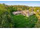 Expansive backyard with lush green lawn, mature trees and a covered patio with a meticulously manicured landscape at 16 Portofino Pl, Durham, NC 27707