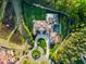 Stunning aerial view of the estate featuring lush landscaping, serene pond, and a grand circular driveway at 16 Portofino Pl, Durham, NC 27707