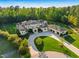 Elegant estate home aerial showcasing extensive grounds, a circular driveway, and a three car garage at 16 Portofino Pl, Durham, NC 27707