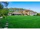 Expansive backyard with lush green lawn and a stepping stone pathway to a meticulously manicured landscape at 16 Portofino Pl, Durham, NC 27707
