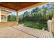 Spacious outdoor balcony with stone floors, columns, and an open view of wooded green landscape at 16 Portofino Pl, Durham, NC 27707