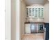 Stylish bar area featuring glass cabinets, granite countertops, and dual wine coolers at 16 Portofino Pl, Durham, NC 27707