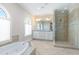 Elegant bathroom with dual sinks, soaking tub, and glass-enclosed shower at 16 Portofino Pl, Durham, NC 27707
