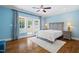 Bright bedroom featuring hardwood floors, a ceiling fan, balcony access, and stylish bedside lamps at 16 Portofino Pl, Durham, NC 27707
