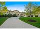 Stunning home featuring a circular driveway, lush landscaping, and elegant architectural details at 16 Portofino Pl, Durham, NC 27707
