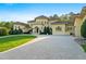 Elegant home featuring a circular driveway, lush landscaping, and stately architectural design at 16 Portofino Pl, Durham, NC 27707