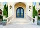 Elegant front entrance with arched doorway, wrought iron doors, and stone steps with potted plants at 16 Portofino Pl, Durham, NC 27707
