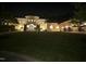 Elegant home exterior at night, showcasing arched windows, manicured lawn, and a circular driveway at 16 Portofino Pl, Durham, NC 27707
