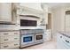 Gourmet kitchen features a Wolf range, custom hood, and granite countertops at 16 Portofino Pl, Durham, NC 27707