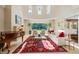 Bright and open living room with fireplace, piano, high ceilings, and large windows overlooking the grounds at 16 Portofino Pl, Durham, NC 27707