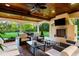 A luxurious outdoor seating area with a fireplace and ceiling fan at 16 Portofino Pl, Durham, NC 27707