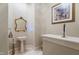 Elegant powder room featuring a pedestal sink with gold fixtures and a decorative mirror at 16 Portofino Pl, Durham, NC 27707
