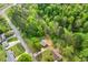 Aerial view showcases a home surrounded by lush greenery, near a serene river at 1751 Riverside Dr, Hillsborough, NC 27278