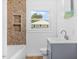 Bathroom with decorative tiled tub and shower featuring a gray vanity at 1751 Riverside Dr, Hillsborough, NC 27278