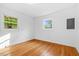 Bright bedroom with hardwood floors, two windows, and white walls at 1751 Riverside Dr, Hillsborough, NC 27278