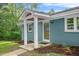 Inviting entryway with a charming covered porch, a solid wood door, and neatly landscaped surroundings at 1751 Riverside Dr, Hillsborough, NC 27278