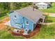 Aerial view of a light blue home with a gray roof, surrounded by lush greenery and a well-maintained lawn at 1751 Riverside Dr, Hillsborough, NC 27278