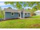 Cozy blue brick home featuring a well-kept lawn, lush landscaping, a covered entry, and a serene outdoor setting at 1751 Riverside Dr, Hillsborough, NC 27278