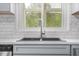 Kitchen sink with stainless steel faucet under a window with a view of lush greenery outside at 1751 Riverside Dr, Hillsborough, NC 27278