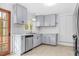 Bright kitchen with light blue cabinets, stainless steel appliances, and a view to the outdoors at 1751 Riverside Dr, Hillsborough, NC 27278