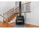 Close up of a fireplace and a staircase, with hardwood floors, white wall panels, and wrought iron railing at 1751 Riverside Dr, Hillsborough, NC 27278
