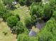 Stunning aerial view of wooded property with a pond and fenced pasture area at 1835 Pearidge Rd, Angier, NC 27501