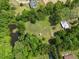 Aerial view of the property, showing a pond and a grassy area surrounded by trees at 1835 Pearidge Rd, Angier, NC 27501