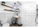 Modern bathroom featuring a walk-in shower, wall mounted sink, new toilet, and subway tile at 1835 Pearidge Rd, Angier, NC 27501