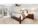 Cozy bedroom with a ceiling fan, carpet floors, French doors and a decorative lamp on the nightstand at 1835 Pearidge Rd, Angier, NC 27501
