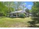 Side view of a quaint one-story house with a metal roof and covered porch, surrounded by trees at 1835 Pearidge Rd, Angier, NC 27501