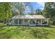 Charming single story home with a sprawling front porch, metal roof and mature trees at 1835 Pearidge Rd, Angier, NC 27501