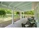 Charming covered front porch with chairs, plants, and views of the expansive front yard at 1835 Pearidge Rd, Angier, NC 27501