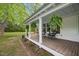 Inviting front porch with seating, potted plants, and hanging ferns on a single-story home at 1835 Pearidge Rd, Angier, NC 27501