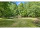 Peaceful pond surrounded by lush green trees and grassy area at 1835 Pearidge Rd, Angier, NC 27501