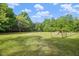 Expansive and well-maintained yard with mature trees and partial fencing at 1835 Pearidge Rd, Angier, NC 27501