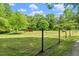 Large, grassy yard featuring mature trees and partial fencing at 1835 Pearidge Rd, Angier, NC 27501