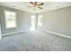Bright bedroom with plush gray carpeting, a ceiling fan, and multiple windows at 186 Gumtop Dr, Zebulon, NC 27597