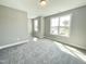 This bedroom offers natural light with its two windows and is enhanced with plush gray carpeting at 186 Gumtop Dr, Zebulon, NC 27597