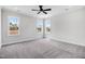Bright bedroom with plush carpet, ceiling fan, and abundant natural light from three windows at 186 Gumtop Dr, Zebulon, NC 27597