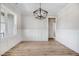 Dining room with modern chandelier, wainscoting, wood-look floors and large window at 186 Gumtop Dr, Zebulon, NC 27597